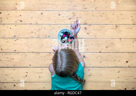 Ragazza distesa sul pavimento con vaso di fiori di teste, vista dall'alto Foto Stock