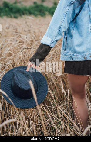 Giovane donna nel campo di mais che trasportano black hat Foto Stock