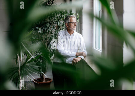 Imprenditore prendendo una pausa, guardando fuori della finestra Foto Stock