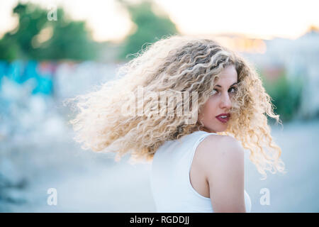 Giovane donna bionda con capelli ricci Foto Stock
