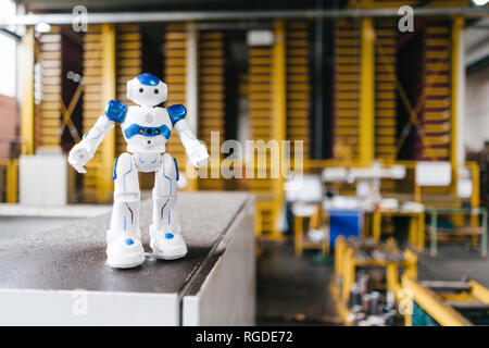 Robot giocattolo in piedi sul ripiano nel centro logistico Foto Stock