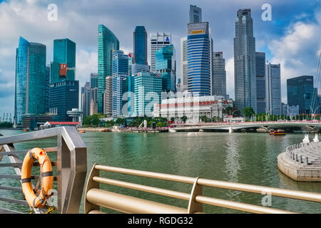 La skyline di Singapore si vede attraverso Marina Bay dalle Esplanade; backgr.: Hotel Fullerton, il Merlion e highrise edifici del quartiere bancario Foto Stock