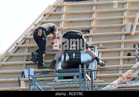 Copritetti installazione nuovo lucernario durante il restauro del tetto Foto Stock