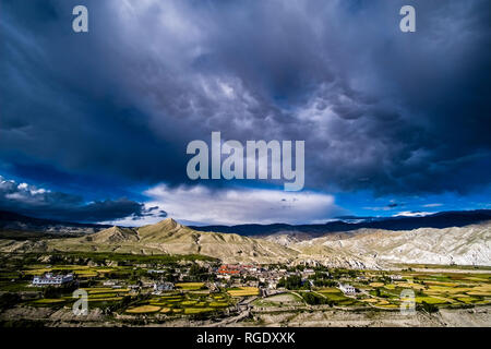 Panoramica vista aerea sulla città, il settore agricolo i dintorni e il paesaggio arido di Mustang superiore, scure nuvole monsoniche avvicinando Foto Stock