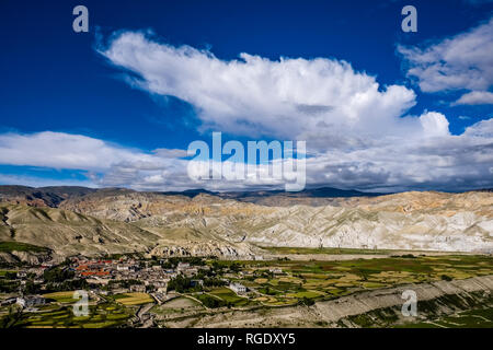 Panoramica vista aerea sulla città, il settore agricolo i dintorni e il paesaggio arido di Mustang superiore, scure nuvole monsoniche avvicinando Foto Stock