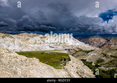 Panoramica vista aerea sul grano saraceno e campi di orzo e il paesaggio arido di Mustang superiore, scure nuvole monsoniche avvicinando Foto Stock