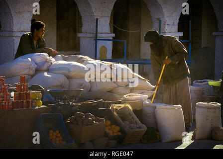 DJANET, Algeria - Gennaio 16, 2002: fornitori sconosciuti al mercato con architettura di arco Foto Stock