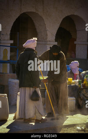 DJANET, Algeria - Gennaio 16, 2002: fornitori sconosciuti al mercato con architettura di arco Foto Stock