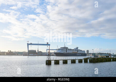 Kiel, Schleswig-Holstein / Germania - 29 Gennaio 2019: la nave di crociera colore fantasia sta entrando in Kiel's Harbor, grande gru di cantiere in background Foto Stock