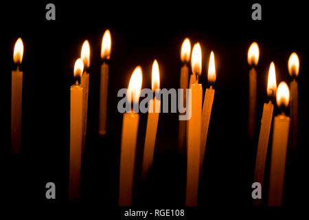 Molti Natale candele accese di notte su sfondo nero. Candela set isolato in sfondo nero. Gruppo di candele accese nel buio con Foto Stock