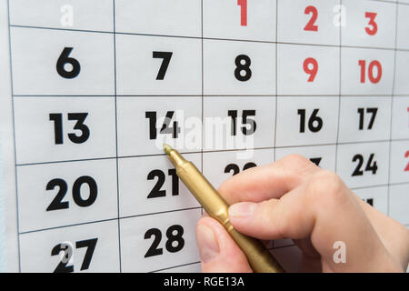 Marcatore a mano indica la data sul calendario da parete Foto Stock