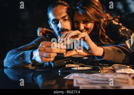 Un criminale coppia giovane tossicodipendente di preparare la cocaina per drugging. Foto Stock