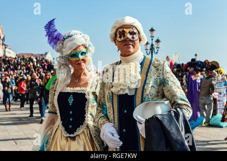 Coppia di partecipanti non identificato usura vintage coloratissimi costumi e maschere durante il famoso e tradizionale Carnevale a Venezia, Italia. Foto Stock