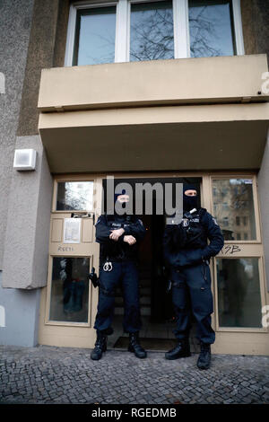 Berlino, Germania. 29 gen, 2019. Gli agenti di polizia sono in piedi di fronte a una casa a Kreuzberg dopo una rapina di un blindato auto in ottobre. Circa tre mesi dopo la rapina spettacolare di un trasportatore di denaro nei pressi di Berlino Alexanderplatz, circa 180 funzionari di polizia cercato gli appartamenti di sospetti. Credito: Christoph Soeder/dpa/Alamy Live News Foto Stock