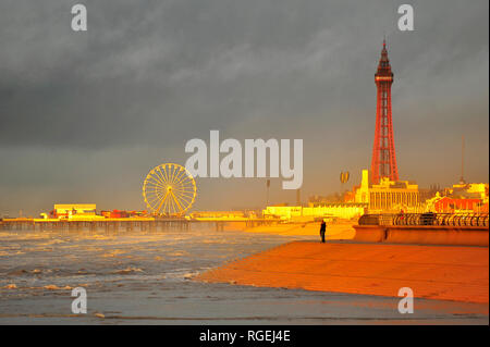 Blackpool, Regno Unito. Il 29 gennaio 2019. Una fredda giornata piovosa culminante in un drammatico tramonto su una marea. Il molo centrale, la ruota panoramica Ferris e dalla Torre di Blackpool bagnato in un bagliore arancione al tramonto. Kev Walsh Alamy/Live News Foto Stock