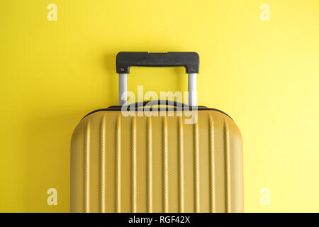 Valigia su sfondo giallo creative minimo concetto di viaggio. Foto Stock