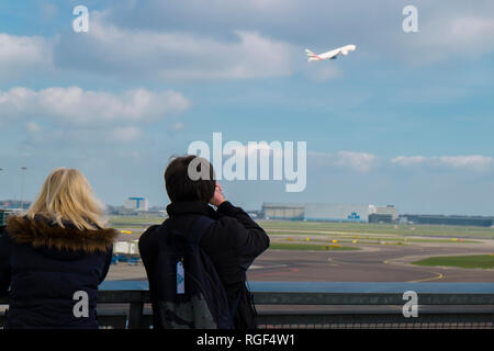 In corrispondenza del piano di piattaforma di osservazione presso l'aeroporto di Schiphol ad Amsterdam nei Paesi Bassi. Guardare la gente KLM decollo. Foto Stock