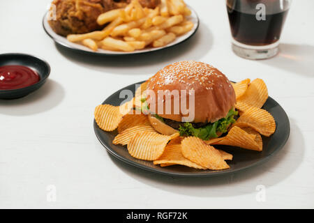 Il fast food hamburger con set fritto croccante di pollo e patatine fritte, ghiaccio cola sul lato Foto Stock