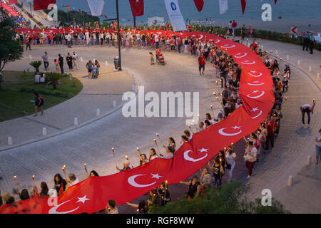 Il 19 maggio 2018; Antalya, Turchia - La gente celebra la gioventù e la giornata dello sport. Parade. Parata annuale con torce e lunga bandiera turca di Antalya, Turchia Foto Stock