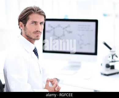 Ritratto di un maschio di scienziato con un monitor guardando le camer Foto Stock
