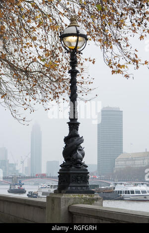 LONDON, Regno Unito - 23 novembre 2018: Foschia mattutina. Vista sul Tamigi e antiche lampione sul lungomare Foto Stock