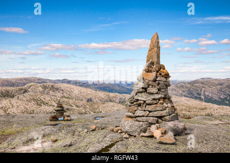 Cairn (un mucchio di pietre) contrassegno trekking in montagna sentiero lungo il Lysefjord a Kjerag (o Kiragg) Plateau, una popolare destinazione turistica in Forsand muni Foto Stock