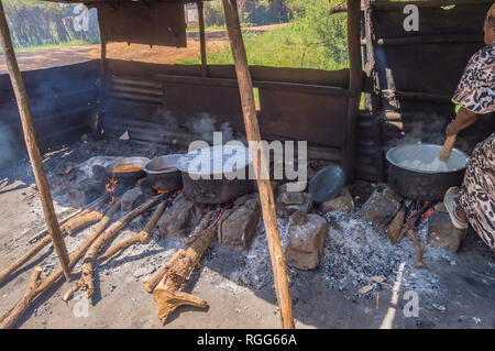 Quattro grandi pentole in appoggio sul log di incendi in un piccolo box di un ristorante nei pressi della città di Thika nel Kenya centrale Foto Stock