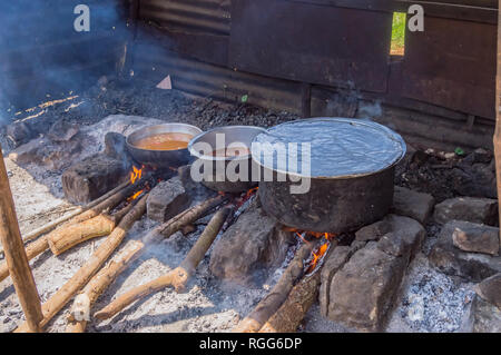 Tre grandi pentole in appoggio sul log di incendi in un piccolo box di un ristorante nei pressi della città di Thika nel Kenya centrale Foto Stock