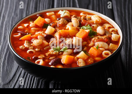 Tradizionale zuppa di fagioli con verdure, ditalini pasta e carne di manzo macinata closeup in una ciotola su una tavola di legno orizzontale. Foto Stock