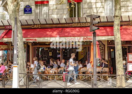 Persone che cenano fuori sul marciapiede al Café le Dôme in Rue Saint-Dominique, in una giornata estiva a Parigi, Francia Foto Stock