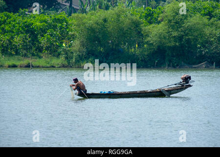 Pescatore vietnamita su una piccola barca da pesca sul Fiume Perfume in tinta, Vietnam, Asia Foto Stock