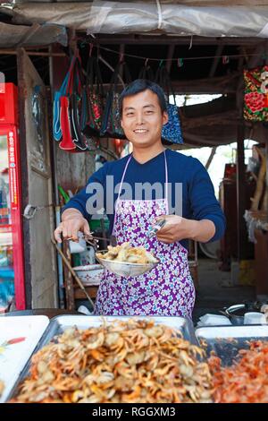 L'uomo la frittura di gamberi di fiume, città dell'Imperatore bianco, Baidi, Provincia di Chongqing Cina Foto Stock