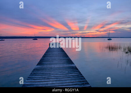 Pontile in legno al tramonto sul Lago Ammersee, Fuenfseenland, Baviera, Germania. Foto Stock