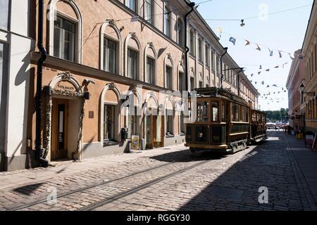 Tram passa attraverso la fila di case, Helsinki, Finlandia Foto Stock