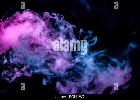 Di Rosa viola e blu fumo ondulato su un isolato nero lo sfondo. Configurazione astratta di vapore da vape di gradualmente in aumento le nuvole. Foto Stock