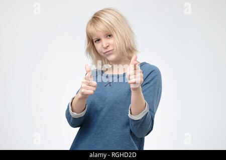 Giovane donna bionda puntare il dito alla telecamera. Foto Stock