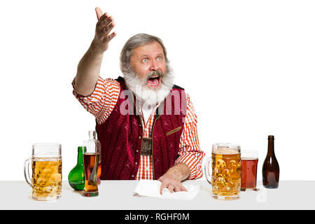 Il senior esperto barman maschio con birra a studio isolato su sfondo bianco. Barman internazionale giorno, bar, alcool, ristorante, birra, party, pub, il giorno di San Patrizio nel concetto di celebrazione Foto Stock