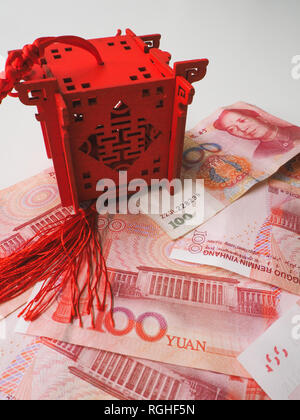 Miniatura padiglione Cinese in rosso brillante in piedi sul cinese 100 renminbi banconote contro uno sfondo bianco Foto Stock