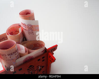 Miniatura padiglione Cinese in rosso brillante riempito con il cinese 100 renminbi banconote contro uno sfondo bianco Foto Stock