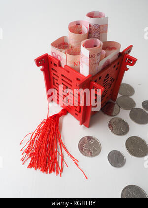 Miniatura padiglione Cinese in rosso brillante riempito con il cinese 100 renminbi banconote e circondato da 1 yuan monete Foto Stock