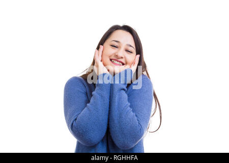 Gioiosa giovane donna in posa tenendo le mani sulle guance di sorridere alla telecamera isolate su sfondo bianco. Foto Stock