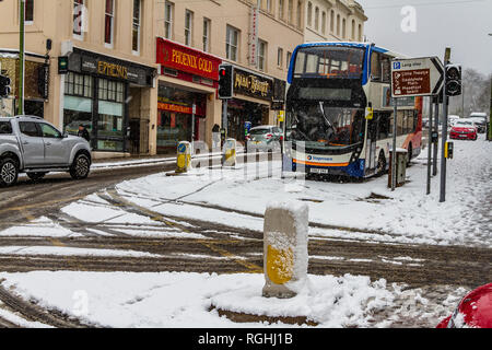 La neve rallenta il traffico e un bus è abbandonato durante la 'bestia da est' su Torwood St in Torquay, Devon. Marzo 2018. Foto Stock