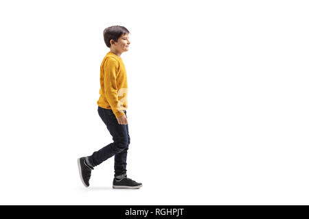 Lunghezza piena ripresa di profilo di un ragazzo a piedi e sorridente isolati su sfondo bianco Foto Stock