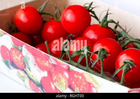 Primo piano di alcuni confezionato Vittoria cherry pomodori a grappolo. Regno Unito Foto Stock