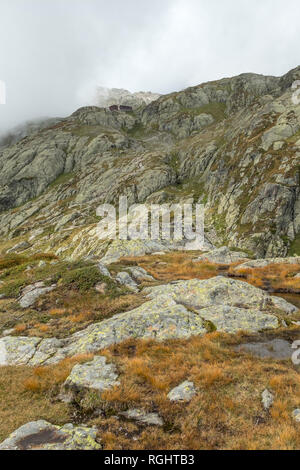 Avvolgimento sentiero conduce gli escursionisti fino a Lac Blanc e il suo rifugio arroccato sulle pendici rocciose ricoperte di erba, muschi e licheni. Colori dell'autunno Foto Stock