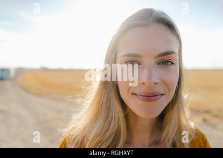 Ritratto di sorridente giovane donna nel paesaggio rurale Foto Stock