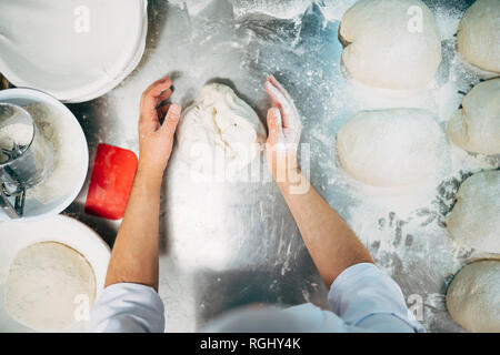 Baker lavora con impasto in forno Foto Stock