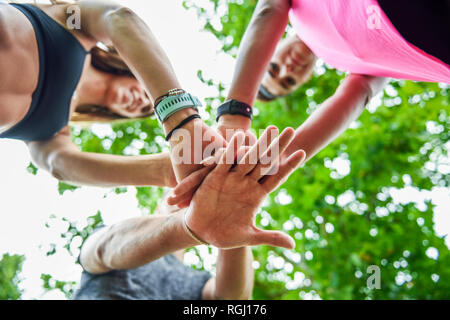 Sport giovane team mani di impilamento, celebrando il successo Foto Stock