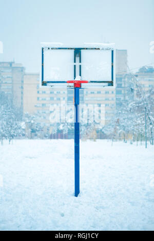Congelati outdoor Basketball hoop in inverno la neve sul vuoto sport parco giochi Foto Stock
