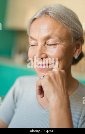 Ritratto di sorridere senior donna con gli occhi chiusi Foto Stock